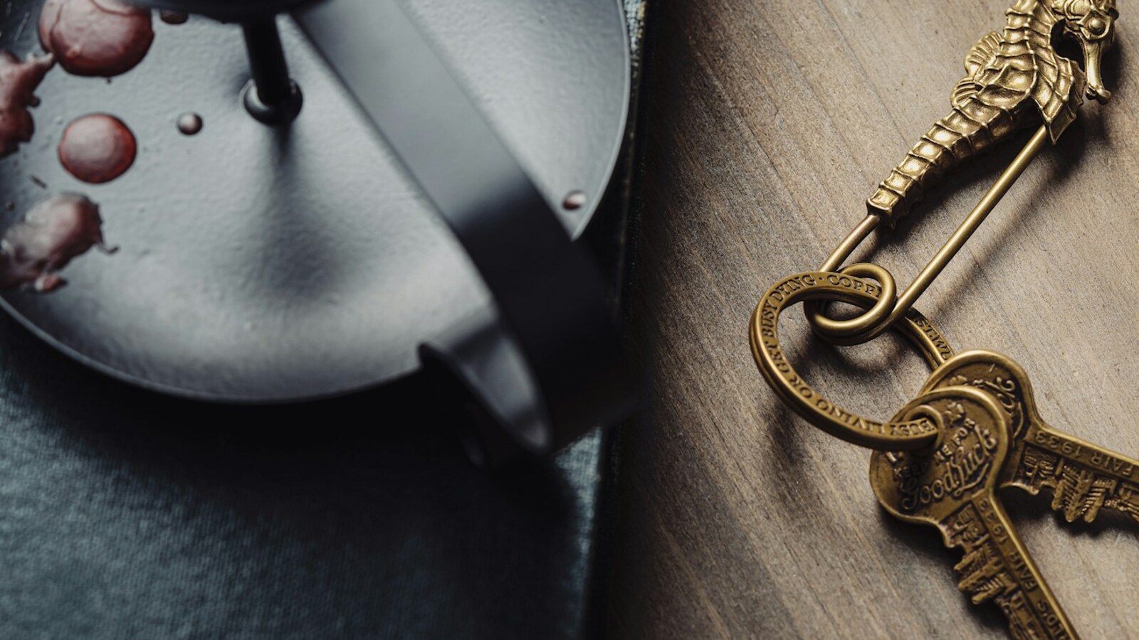 An antique brass key on dark wood